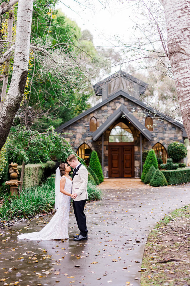 sri lankan bride and irish groom standing outside the chapel at gold creek in canberra